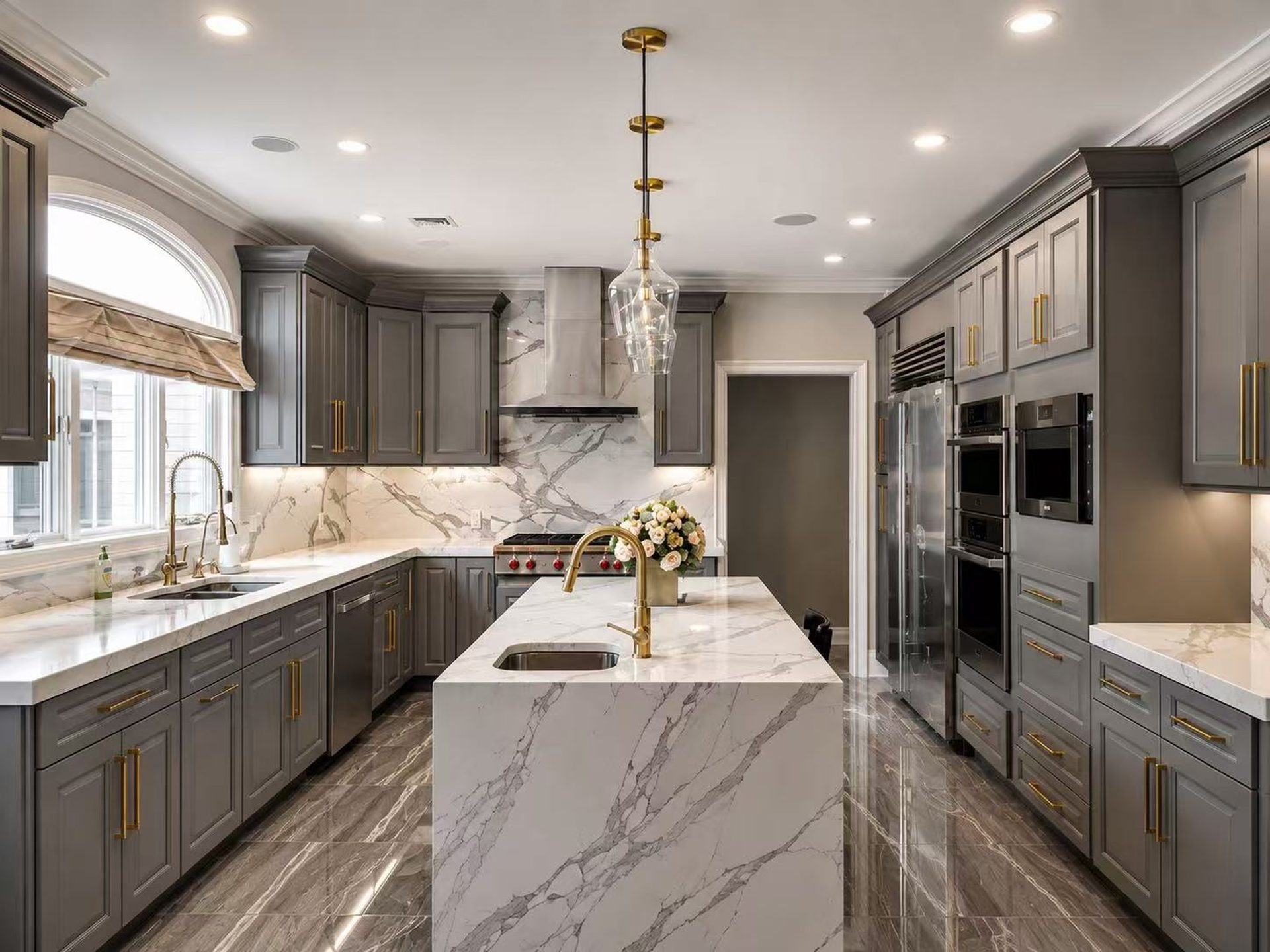 Sage green kitchen with white marble island and gold pendants