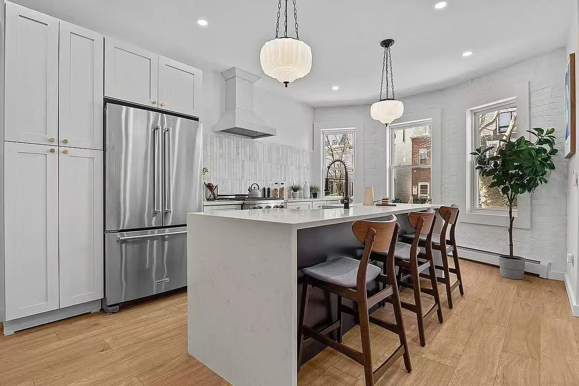 White kitchen with large island beneath a vaulted ceiling